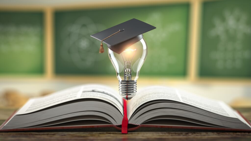 Education, learning on school and university or idea concept. Open book with light bulb and graduation cap on classroom blackboard background. 3d illustration